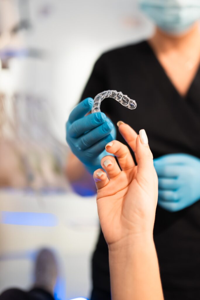 Dentist handing clear aligners to the patient