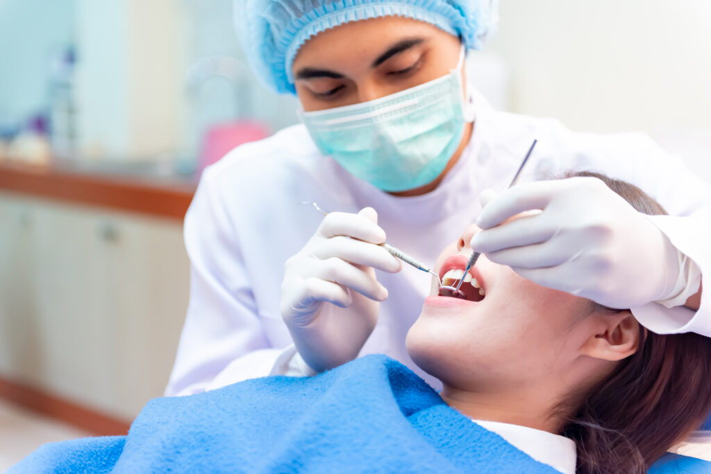 Dentist assessing a patient’s tooth for root canal vs extraction decision during dental examination