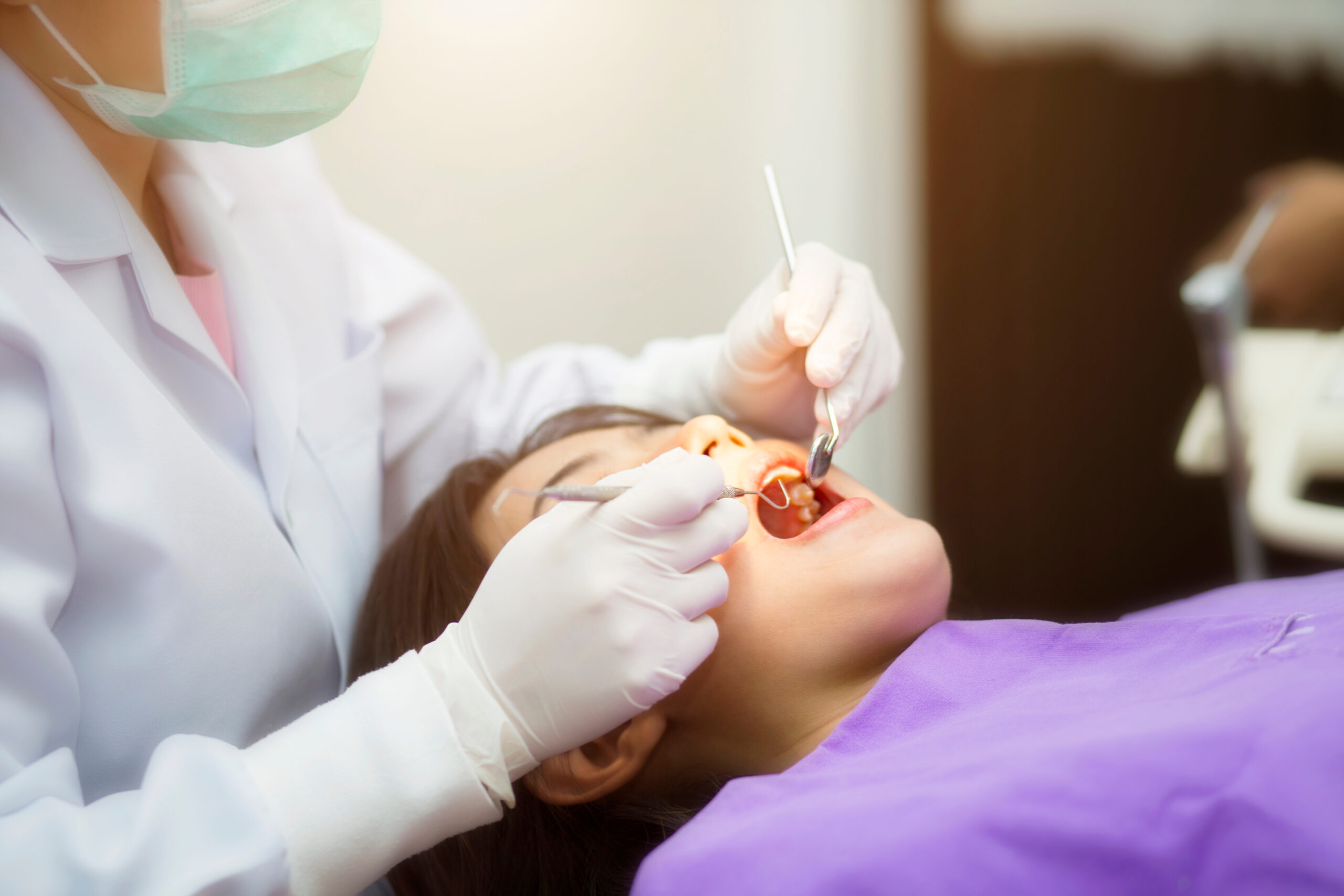 an image of a dentist doing a dental extraction on a patient