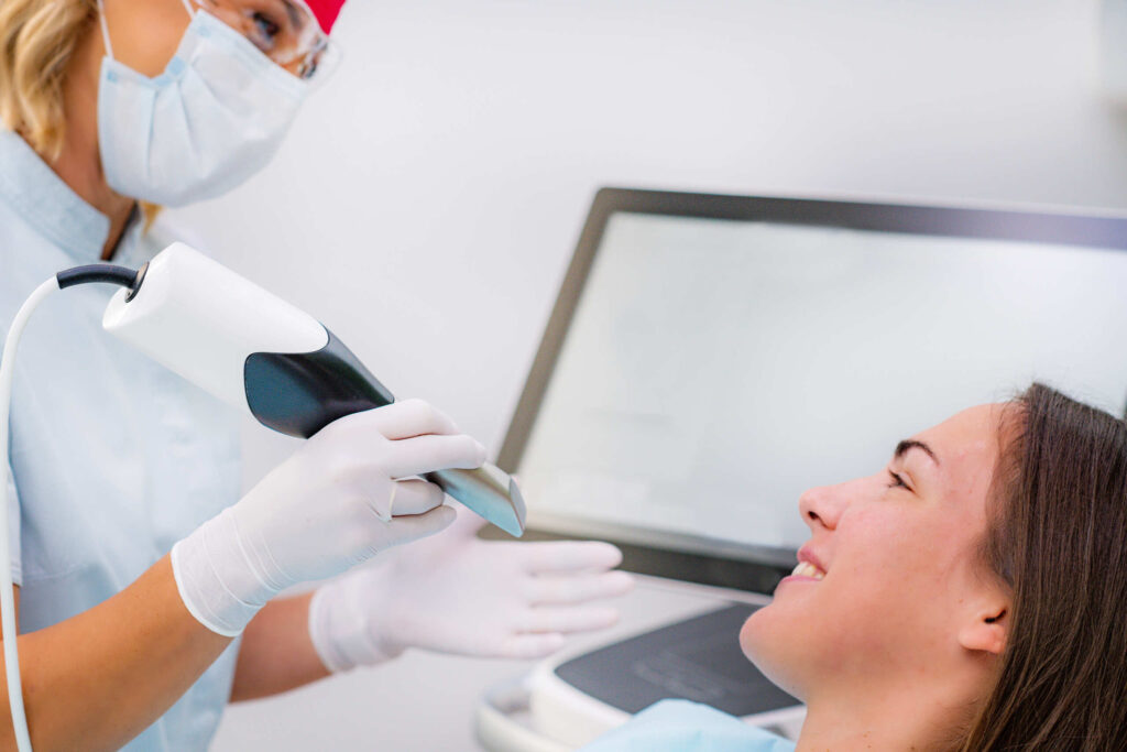a dentist using an intraoral scanner as first step in the client's smile makeover journey in Singapore