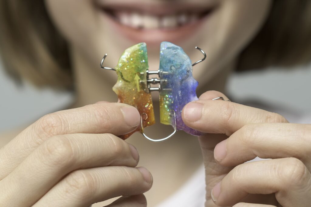 a girl holding a palatal expander as an advised option of orthodontics in Singapore